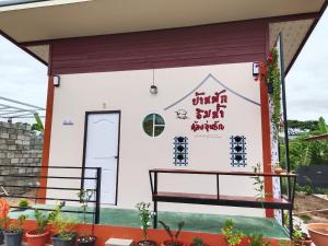 a small building with writing on it at บ้านริมน้ำอุ่นรัก in Ban Na Kai