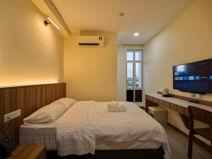 a bedroom with a bed and a desk and a tv at Weiss Hotels Kepong Baru in Kuala Lumpur
