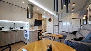 a kitchen and living room with a couch and a table at Apartament Coco Xanel- Parking- WiFi - Klimatyzacja- FV in Łódź