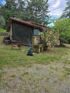 un petit hangar avec une table et des fleurs dans une cour dans l'établissement L'orée des 3 Rivières, à Is-sur-Tille