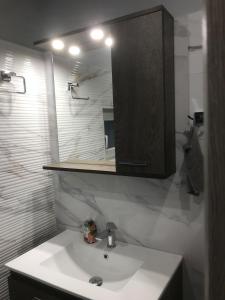 a bathroom with a white sink and a mirror at Διαμέρισμα στο κέντρο της πόλης in Thiva
