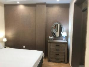 a bedroom with a white bed and a mirror at Διαμέρισμα στο κέντρο της πόλης in Thiva