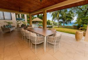 an outdoor patio with a wooden table and chairs at Valmer Resort and Spa in Baie Lazare Mahé
