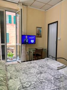 a bedroom with a bed and a flat screen tv at Albergo fiorita in Genoa