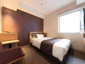 a hotel room with a bed and a window at KEIKYU EX INN Tokyo Nihombashi in Tokyo