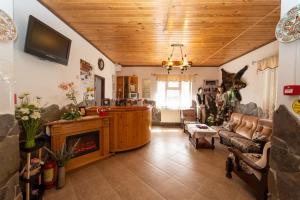 a living room with a couch and a fireplace at Pensiunea Moeciu Casa Wiarusti in Moieciu de Sus