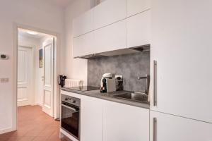 a kitchen with white cabinets and a sink at Lecco City Center Lake Como in Lecco