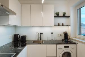 コー​​ブルクにあるAppartement VestePanoramaのシンクと洗濯機付きのキッチン