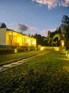 a house lit up at night with a yard at The Angga House in Bangli +38 photos