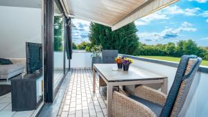 a patio with a table and chairs on a balcony at Moderne 3-Zimmer Wohnung nähe Messe in Cologne