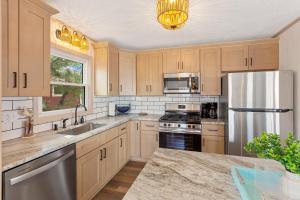 a kitchen with wooden cabinets and a stainless steel refrigerator at 5206 - Hogg Heaven in Croatan Shores