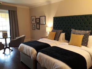a bedroom with two beds and a large headboard at New House Country Hotel in Cardiff +30 photos