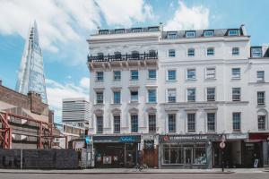 Un gran edificio blanco en una calle de la ciudad con un campanario. en St Christopher's Inn London Bridge - The Village, en Londres