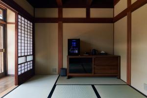 a living room with a tv in a room at Travel Stop UNNOWA in Tomi