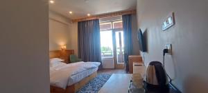 a bedroom with a bed and a large window at Sintik Residency in Leh