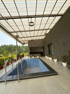a swimming pool in a building with a ceiling at Arzen Farms in Zirakpur