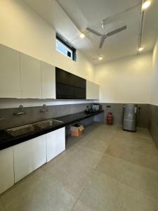 a large kitchen with white cabinets and a sink at Arzen Farms in Zirakpur