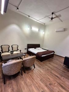 a room with two beds and a table and chairs at Arzen Farms in Zirakpur +5 photos