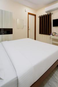 a large white bed sitting in a room at Via Shri Hanuman Ji in Bengaluru
