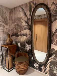a mirror in a room with a chair and a stool at Hilton Garden Inn Tirana in Tirana