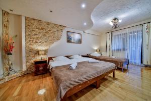 a bedroom with two beds and a brick wall at Domek i Pokoje z widokiem na Tatry - U Magdy Zakopane in Zakopane
