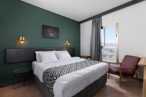 a hotel room with a large bed and a window at Comfort Hotel and Spa - Adults Only in Eilat