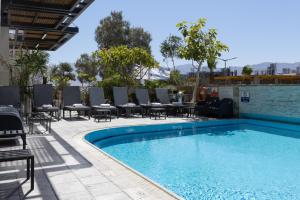 a swimming pool with chairs and a table next to it at Comfort Hotel and Spa - Adults Only in Eilat