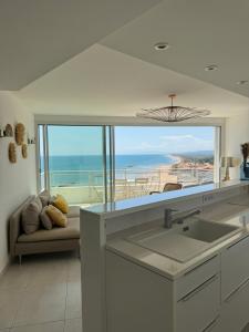 a kitchen with a sink and a view of the ocean at La Grande Tour in Valras-Plage
