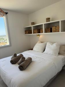 a large white bed with brown towels on it at La Grande Tour in Valras-Plage