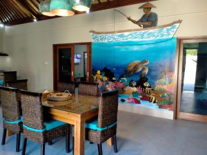 a dining room with a table and an aquarium at Gili Palms Villas in Gili Trawangan