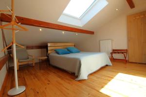 Un dormitorio con una cama con almohadas azules y una ventana. en Gîte de groupe Le Clos du Sapin Bleu à Saint-Dié-des-Vosges, Nature&Convivialité, en Saint-Dié-des-Vosges