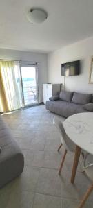 a living room with a couch and a table at Apartmani ROKO in Neum