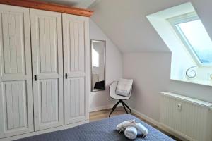 a bedroom with a bed and a chair and a window at Haffblick Whg Ha16 in Boltenhagen