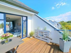 a wooden deck with a table and some plants at Haffblick Whg Ha16 in Boltenhagen