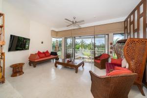 un salon avec des canapés, des chaises et une télévision dans l'établissement Stylish Thai 2BR Condo Pool & Golf with Balcony, à Laguna Phuket