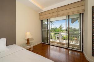 une chambre avec un lit et une grande fenêtre dans l'établissement Stylish Thai 2BR Condo Pool & Golf with Balcony, à Laguna Phuket 48 autres photos