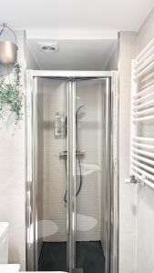 une salle de bain avec une douche avec une porte vitrée dans l'établissement Urban design at Cuatro Caminos, Bernabeu, Madrid, à Madrid 48 autres photos