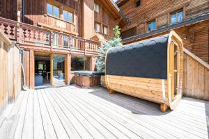 Les BruyèresにあるChalet Gabrielle Luxe ski aux piedsの木製のデッキの上に置かれた大きな木製の物体