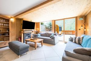 Les BruyèresにあるChalet Gabrielle Luxe ski aux piedsのソファとテーブルのあるリビングルーム