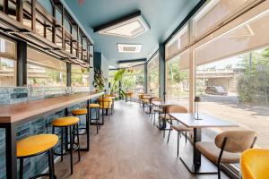 a bar with yellow chairs and tables in a restaurant at tecnopolo aparthotel in Bologna