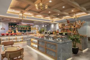 a restaurant with a large counter with tables and chairs at PHUC LONG LUXURY Hotel Danang in Danang