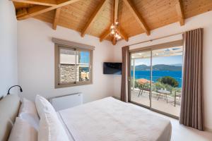 a bedroom with a bed and a view of the ocean at Diamanti Villas in Nikiana +102 photos