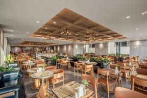 a restaurant with tables and chairs and a bar at PHUC LONG LUXURY Hotel Danang in Danang