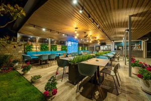 an outdoor patio with tables and chairs and plants at Sunny Flower Family Hotel in Sunny Beach