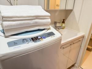 a pile of towels sitting on top of a dishwasher at NDZ103 3 min walk to station, 2 lines, Yamanote Line, high-speed Wi-Fi in Tokyo +48 photos