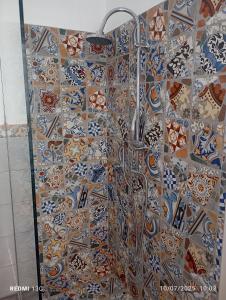 a shower in a bathroom with tiles on the wall at The stars apartment in Olbia