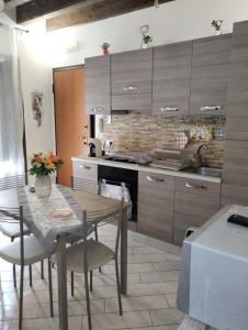 una cucina con tavolo, sedie e lavandino di Grecale Apartment a Trapani