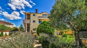 a house with trees and bushes in front of it at Sonnengarten floor 1 in Marčana