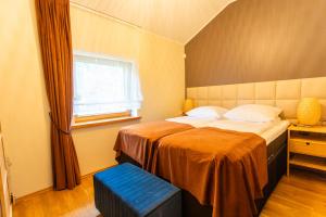 a bedroom with a bed with a blue stool in it at Poilsio sodyba "Spalio krantas" in Giedraičiai