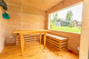 a sauna with a wooden table and a window at Poilsio sodyba "Spalio krantas" in Giedraičiai